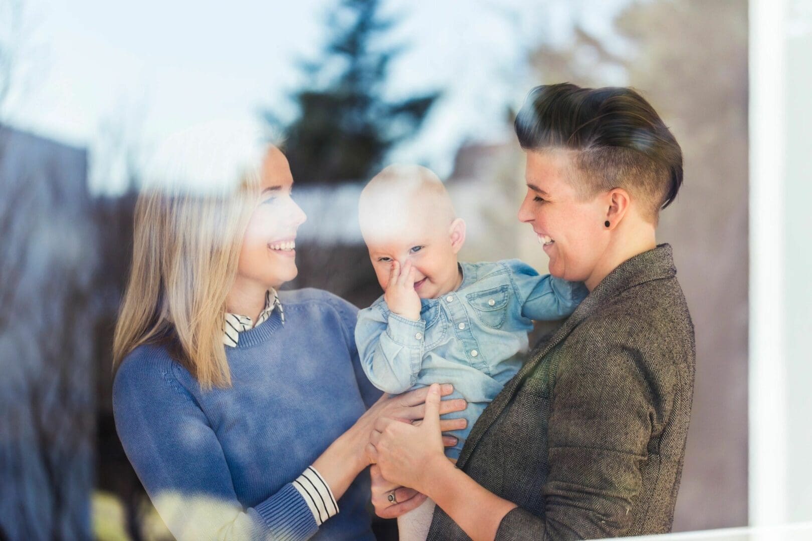 A woman holding a baby and another person