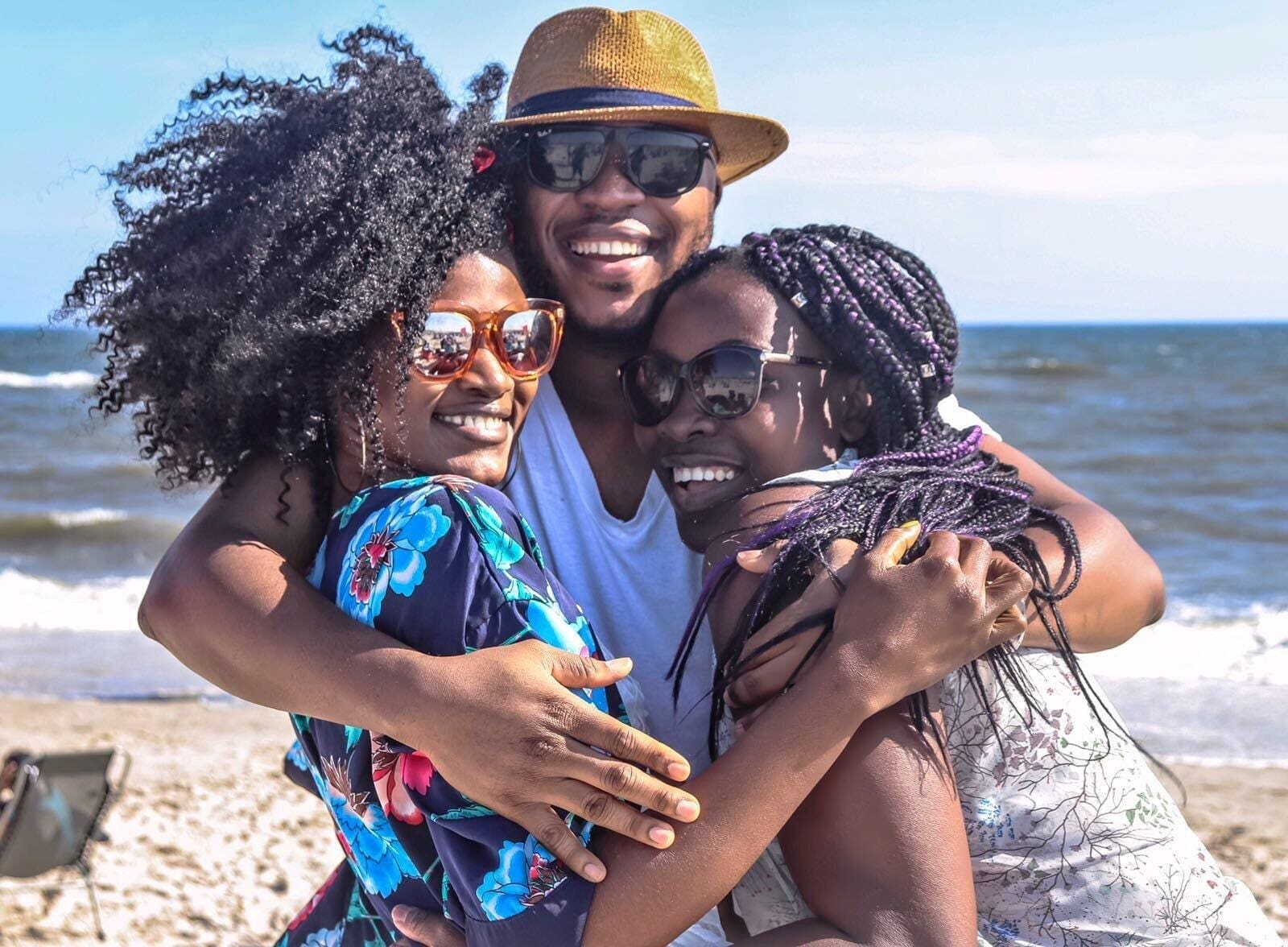 A group of people that are hugging on the beach