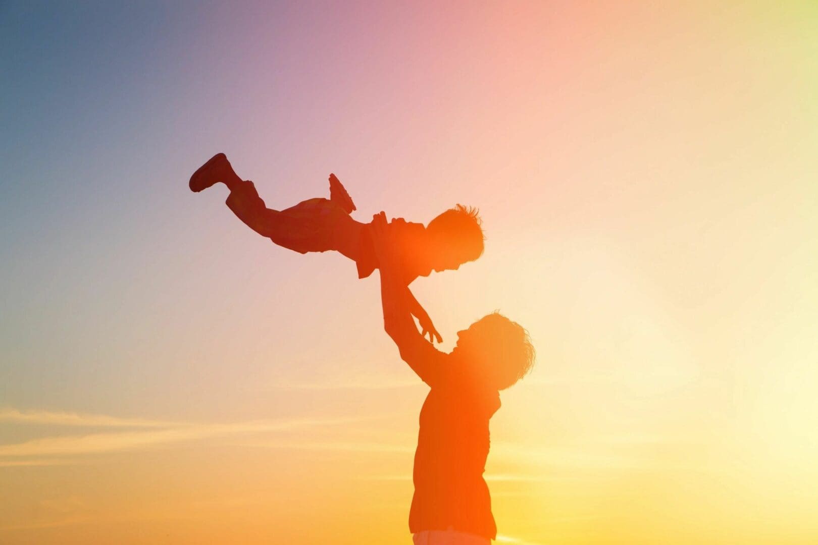 A man holding up a child in the air.