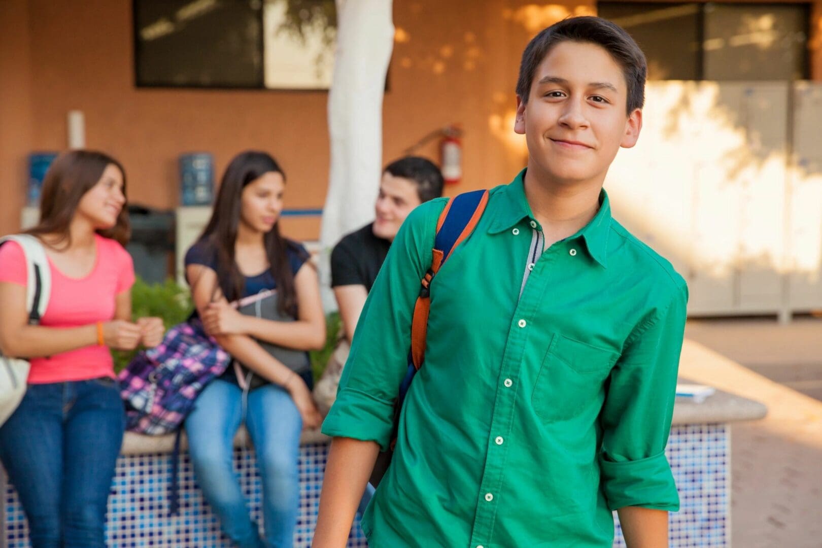 A young man in green shirt and blue jeans.